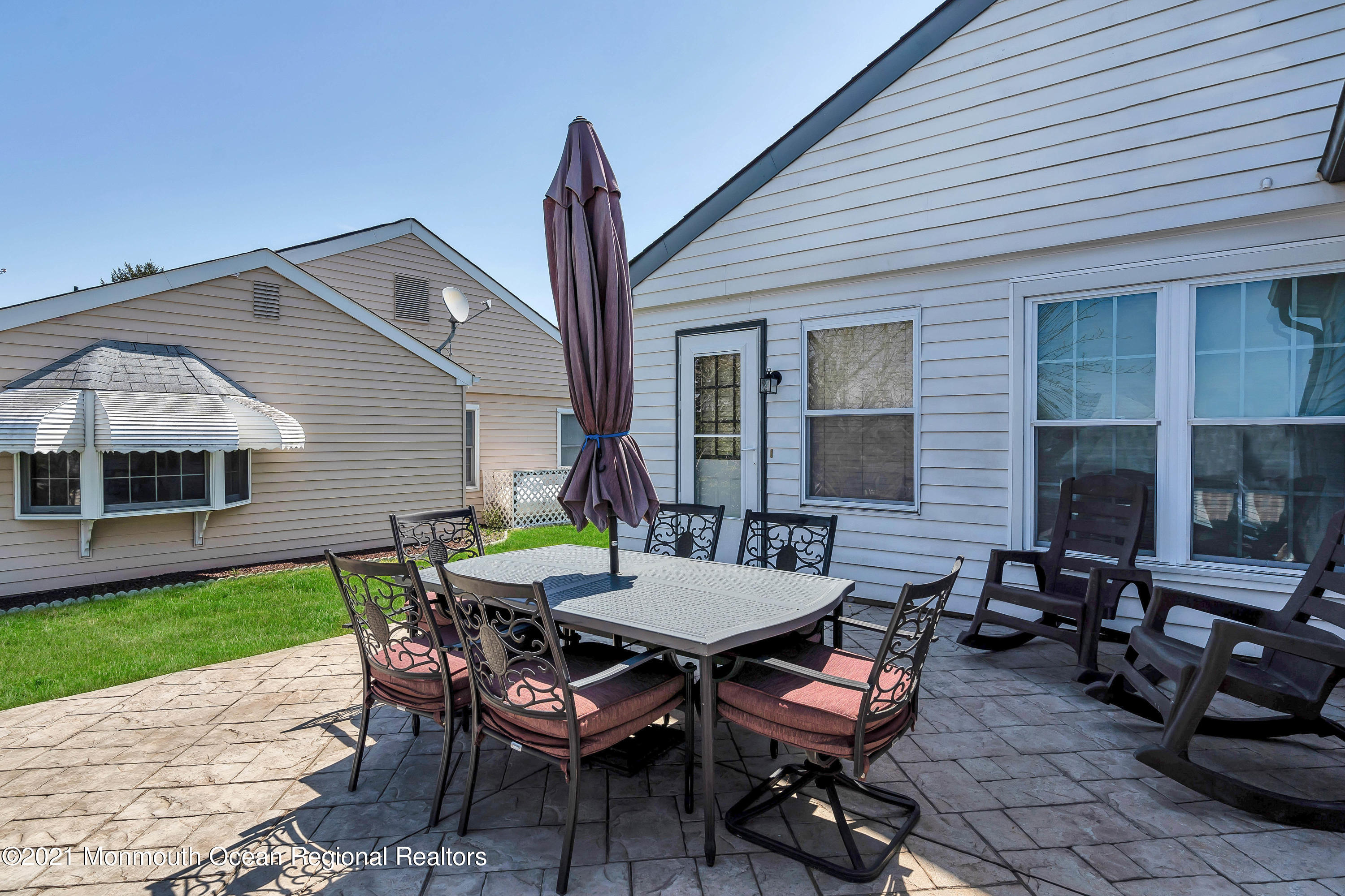 14 Maidstone Way Manchester Township, NJ 08759 - Photo 45 of 49 a patio with a table and chairs and potted plants