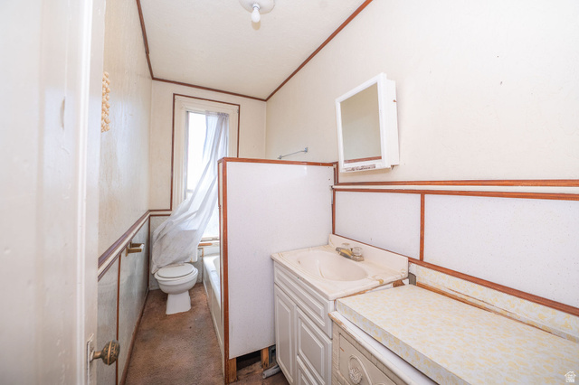 1256 24th Street Ogden, UT 84401 - Photo 21 of 34 Bathroom featuring a built-in vanity with integrated sink, wall-mounted medicine cabinet, bathtub, and toilet