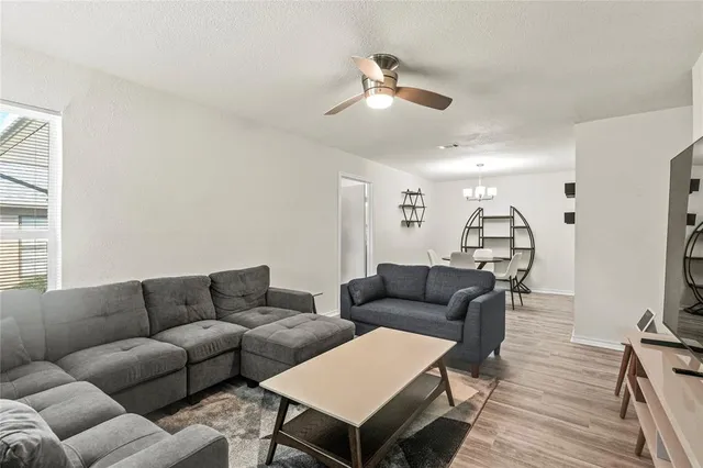 a living room with furniture a ceiling fan and a window