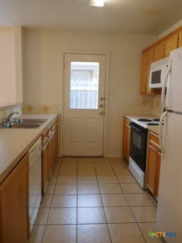 a kitchen with a stove a sink and a refrigerator