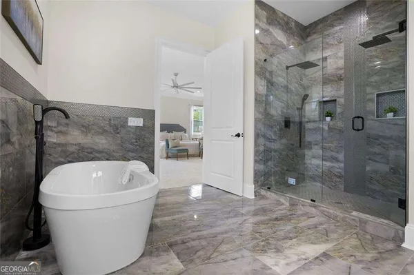 a white bath tub sitting next to a shower