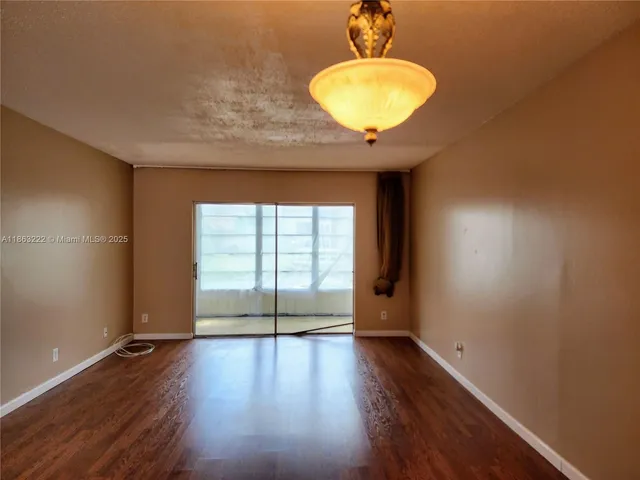 a view of wooden floor and window in a room