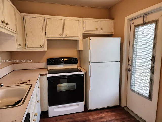 a kitchen with refrigerator and cabinets