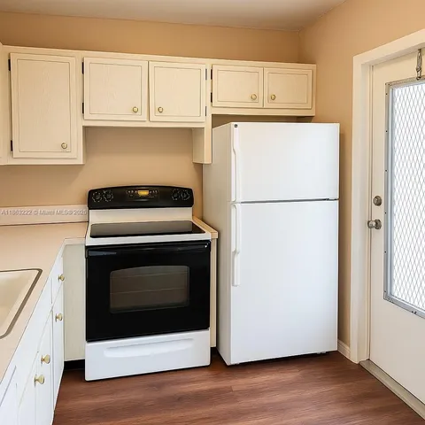 a white refrigerator freezer and a stove sitting inside of a kitchen
