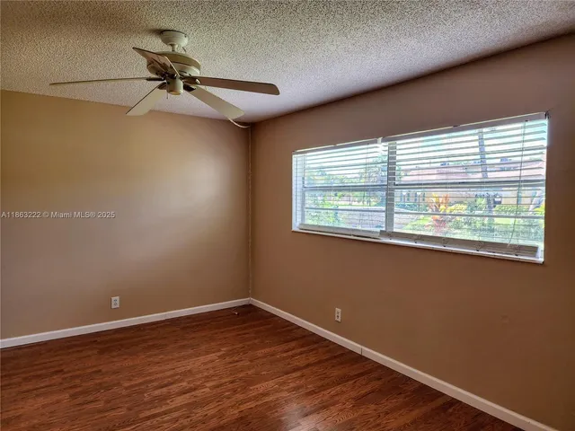 a view of a room with wooden floor and windows