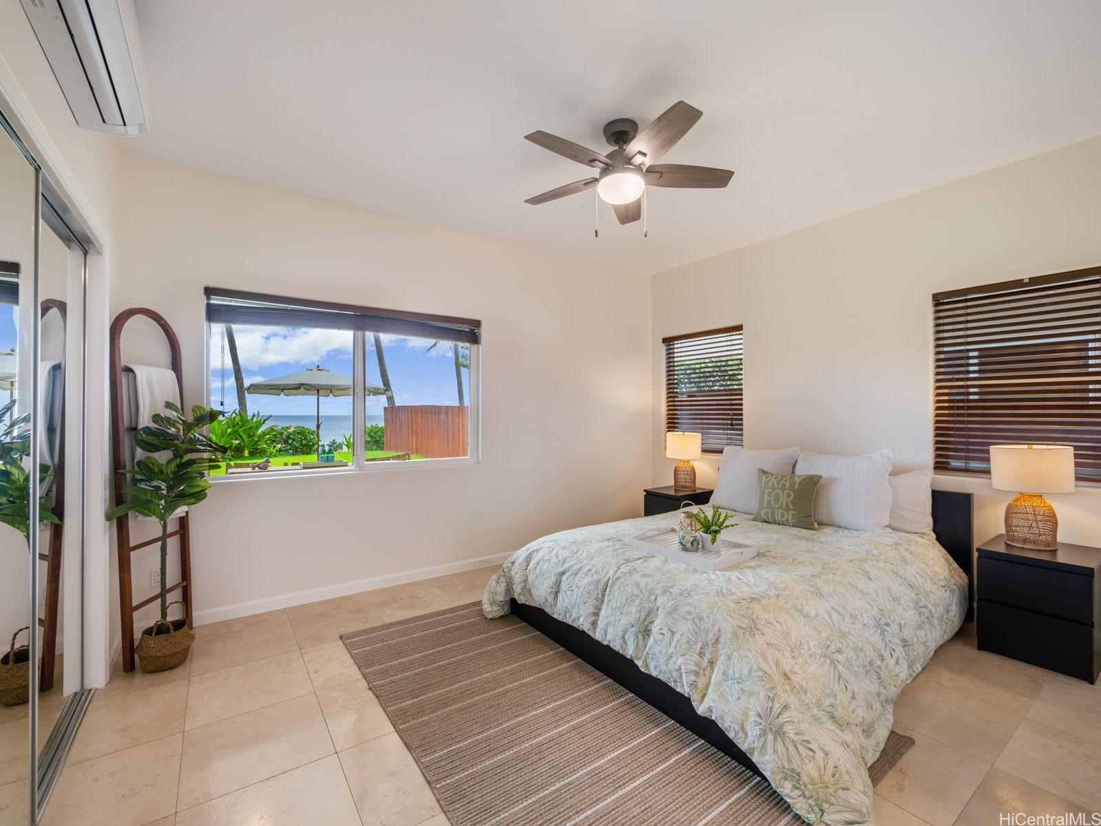 59-355 Ke Nui Road Haleiwa, HI 96712 - Photo 22 of 25 a bedroom with a large bed and a potted plant