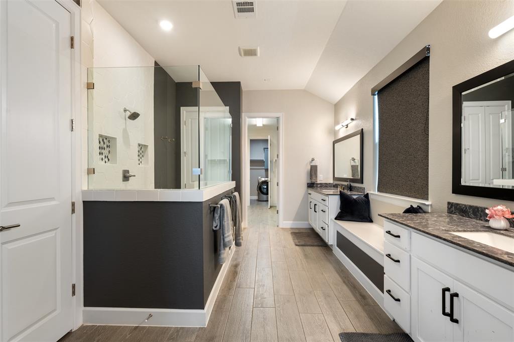 1012 Quarry Point Pass Leander, TX 78641 - Photo 17 of 39 A well-appointed primary bathroom showcases dual vanities, a spacious walk-in shower, and stylish flooring.