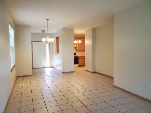 a view of a hallway with wooden floor and a refrigerator