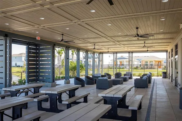 a front view of a house with swimming pool and porch with furniture