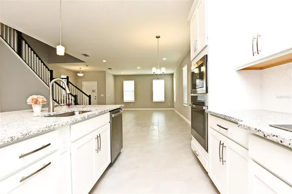 a kitchen with granite countertop white cabinets and white appliances