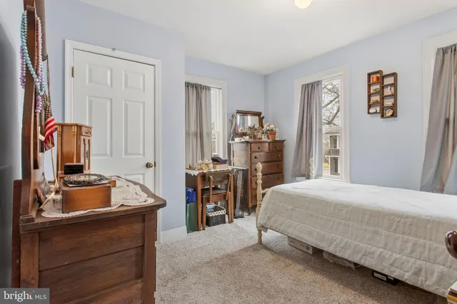 a bedroom with a bed and large mirror on dresser