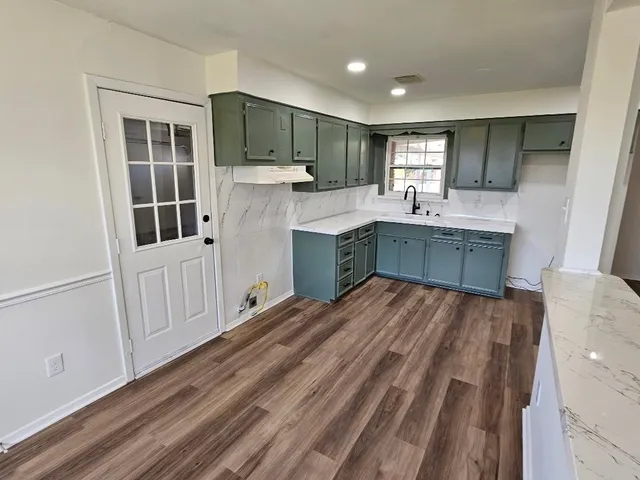 a kitchen with a sink cabinets and wooden floor