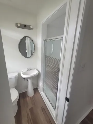 a view of an empty room with a window and a kitchen
