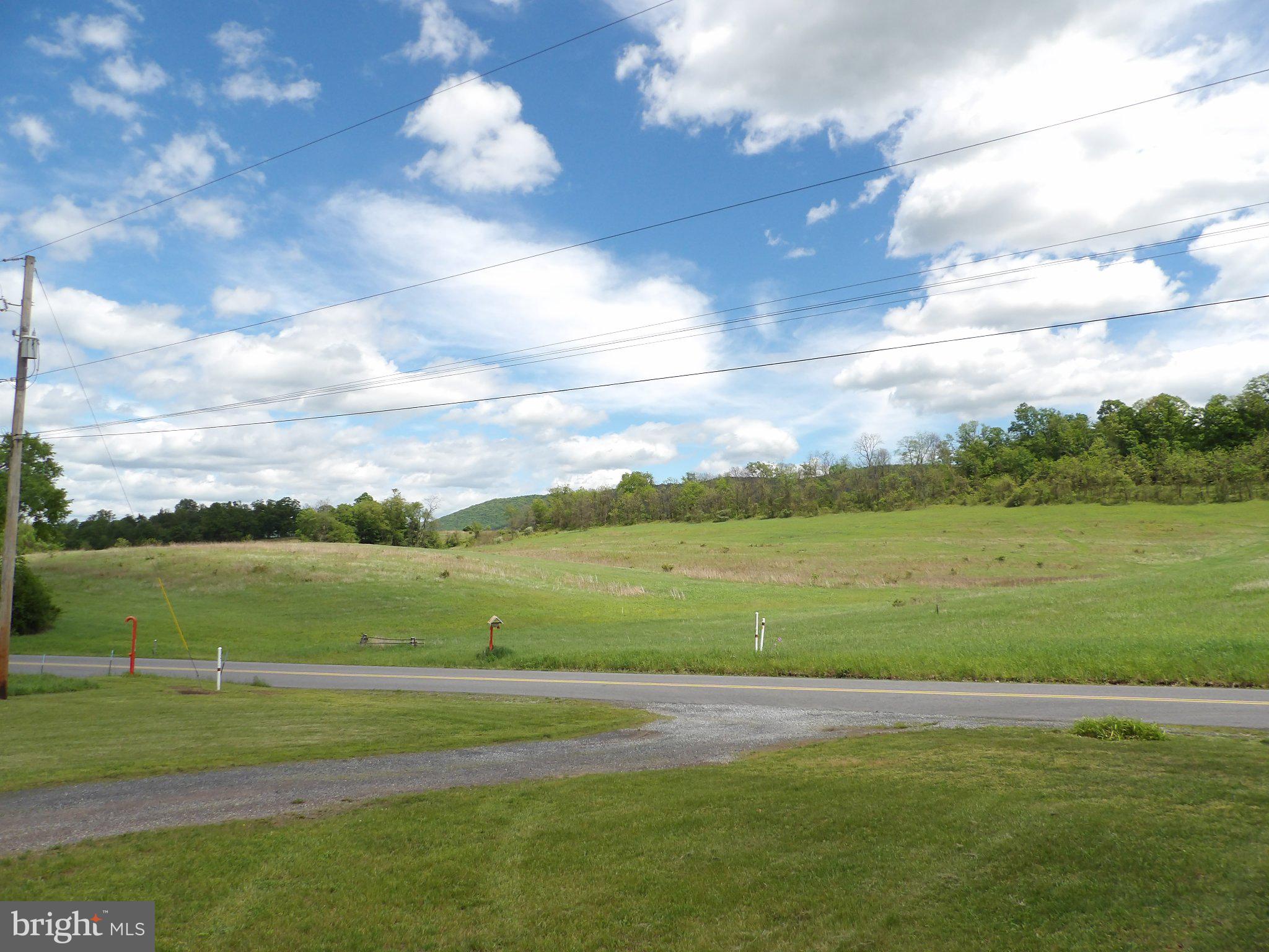 1045 Lockport Road Lewistown, PA 17044 - Photo 38 of 51 Expansive green fields under blue skies.