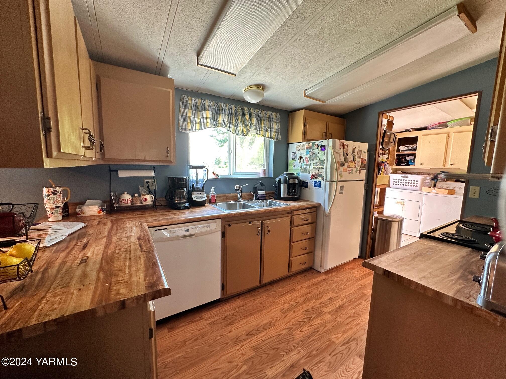 1131 County Line Road Grandview, WA 98930 - Photo 3 of 11 a kitchen with refrigerator a window and cabinets