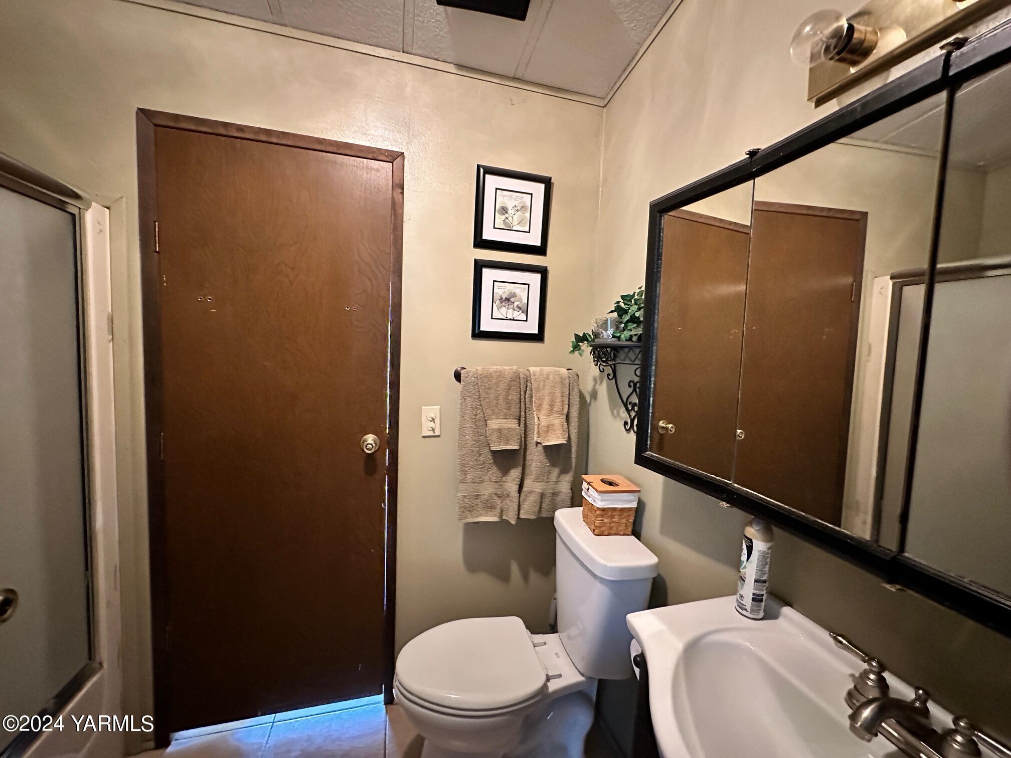 1131 County Line Road Grandview, WA 98930 - Photo 6 of 11 a white toilet sitting next to a bathroom sink