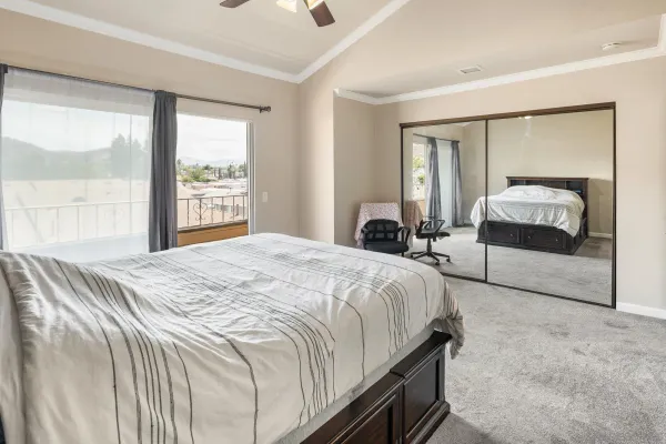 a bedroom with a bed and a large window