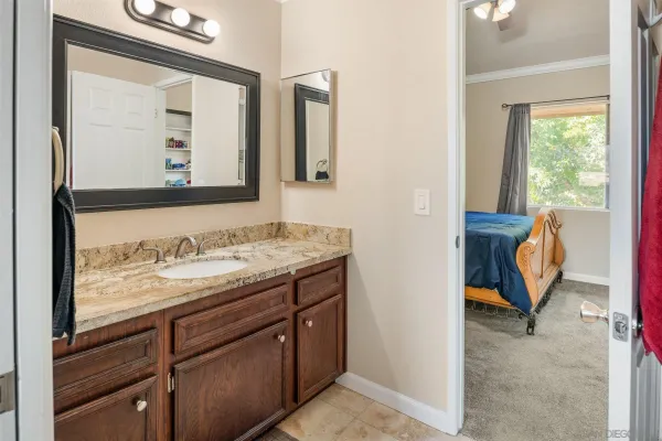 a bathroom with a granite countertop sink and a mirror