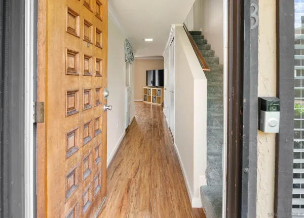 a view of a hallway with wooden floor and entryway