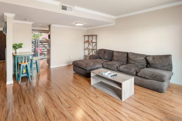 a living room with furniture and a wooden floor