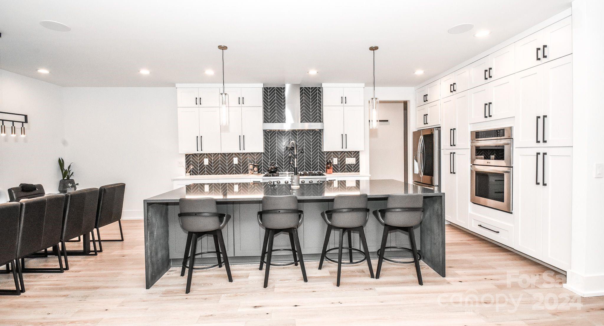 322 Mountainview Drive Charlotte, NC 28270 - Photo 12 of 47 a kitchen with stainless steel appliances kitchen island granite countertop a dining table chairs and white cabinets