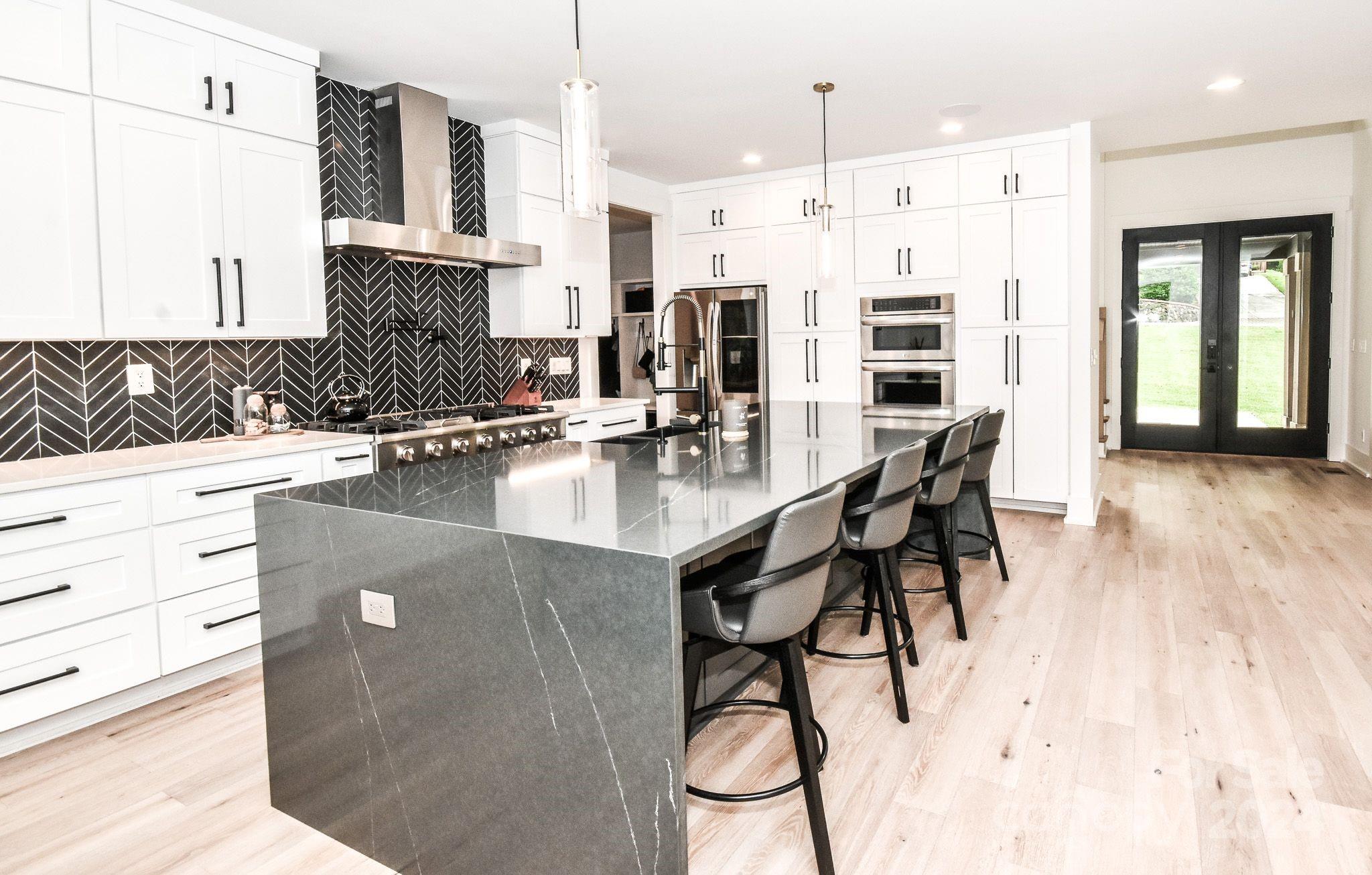 322 Mountainview Drive Charlotte, NC 28270 - Photo 14 of 47 a kitchen with stainless steel appliances kitchen island granite countertop a table chairs in it and wooden floors