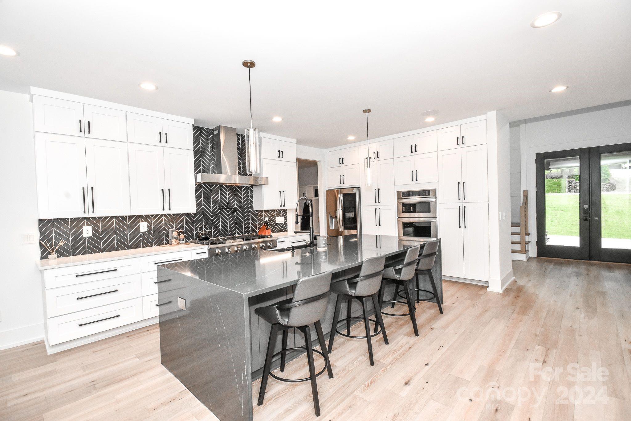 322 Mountainview Drive Charlotte, NC 28270 - Photo 9 of 47 a kitchen with stainless steel appliances kitchen island granite countertop a table chairs and a refrigerator