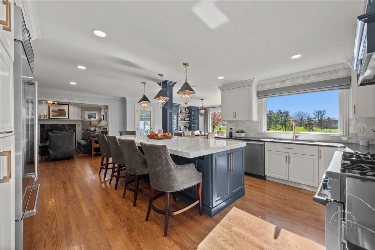 958 West Bauer Road Naperville, IL 60563 - Photo 12 of 57 a kitchen with stainless steel appliances granite countertop a sink dishwasher a stove a dining table and chairs with wooden floor