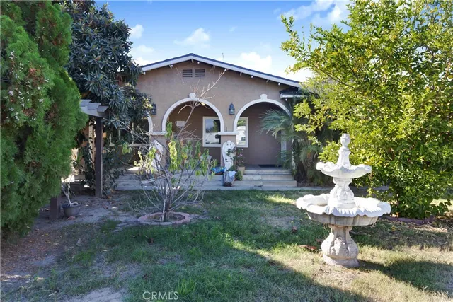 a front view of a house with a yard garage and fountain