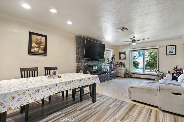 a living room with furniture a flat screen tv and a dining table