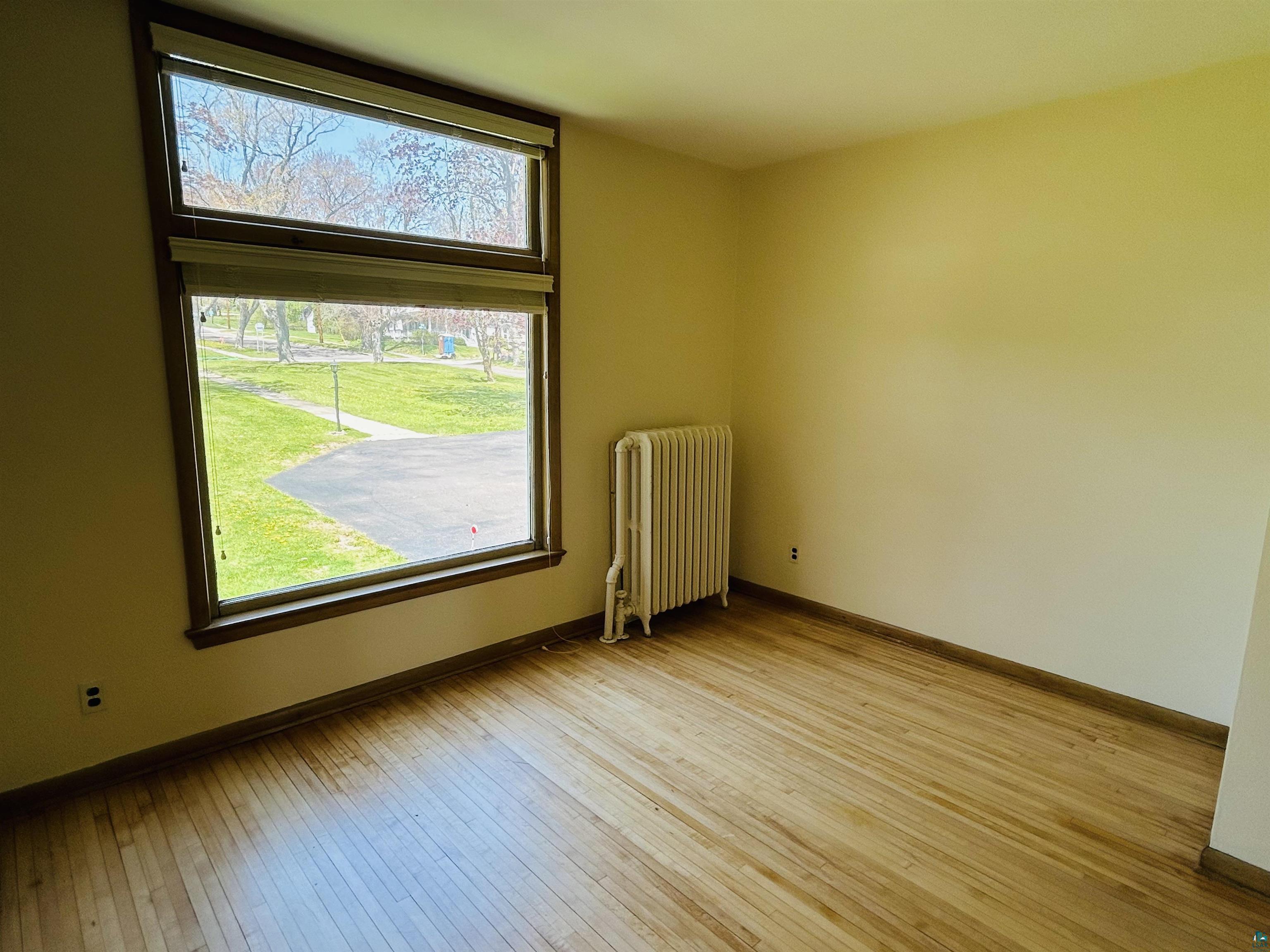 5090 London Road, Unit 1 Duluth, MN 55804 - Photo 20 of 54 Hardwood flooring complements neutral wall tones and a classic radiator