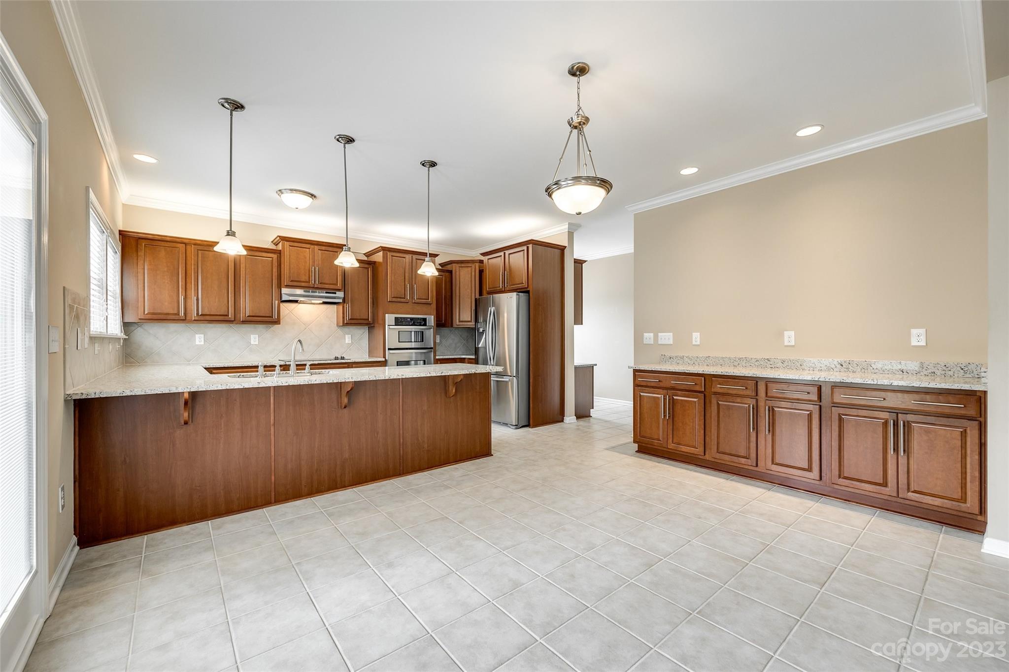 8055 Bryson Road Indian Land, SC 29707 - Photo 21 of 45 a large kitchen with kitchen island granite countertop a large counter top and stainless steel appliances