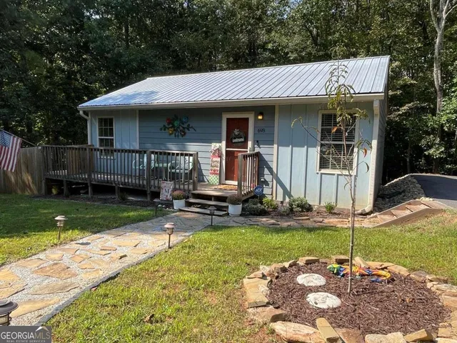 a patio with a table and chairs and potted plants