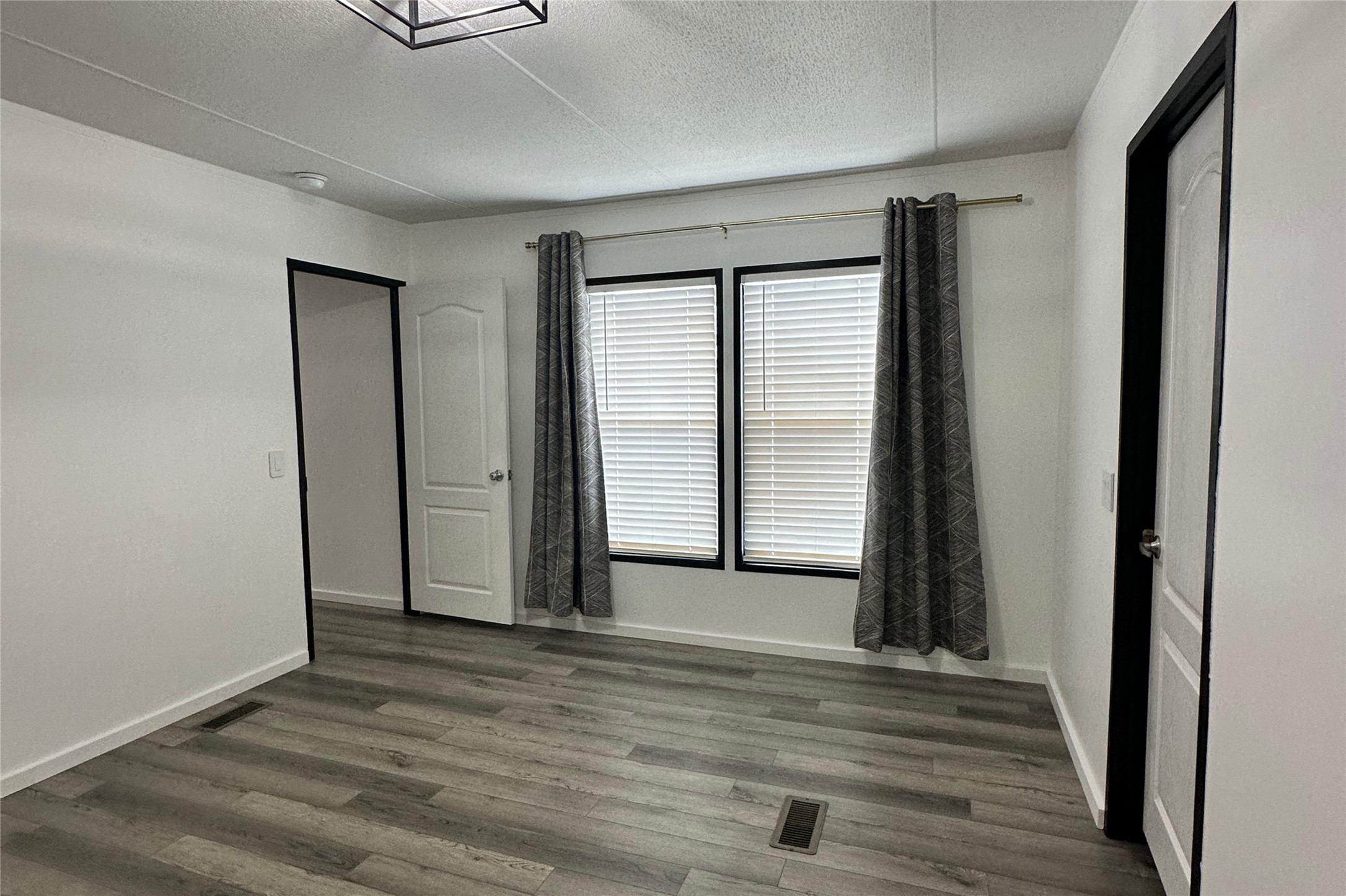 1601 East Slaughter Lane, Unit 464 Austin, TX 78747 - Photo 12 of 26 Unfurnished bedroom featuring dark wood-style flooring and a textured ceiling