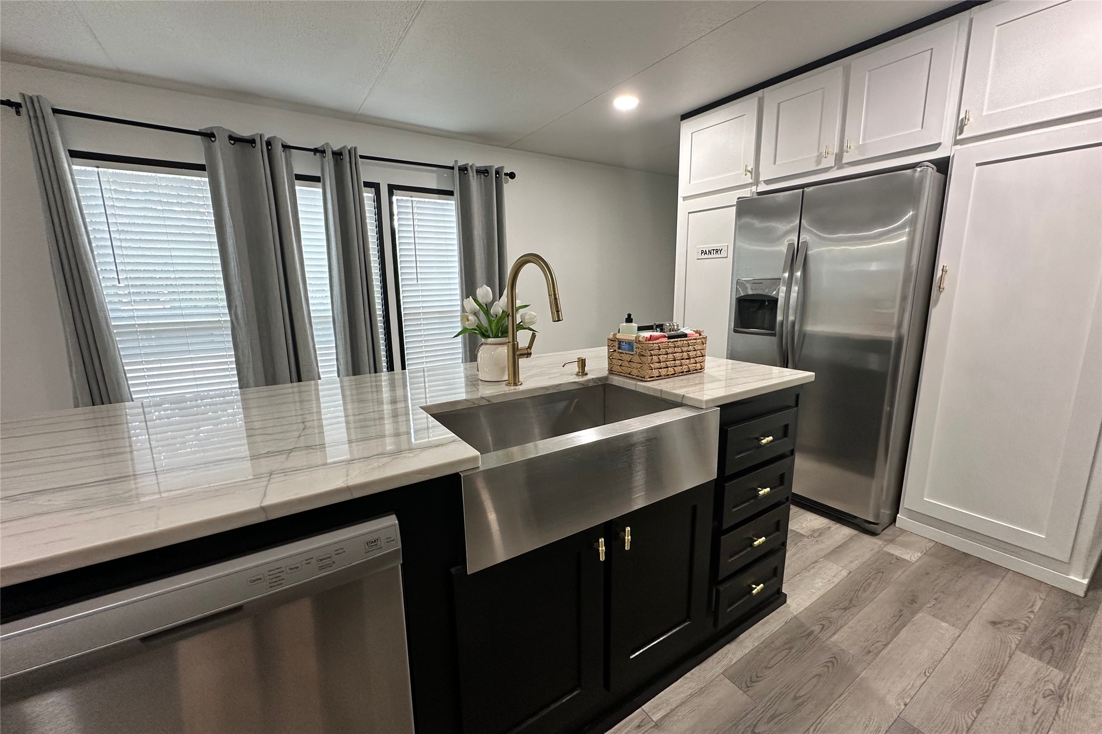1601 East Slaughter Lane, Unit 464 Austin, TX 78747 - Photo 20 of 26 Dual tone kitchen with stainless steel appliances, light wood-type flooring, light stone counters, recessed lighting, and two tone cabinets
