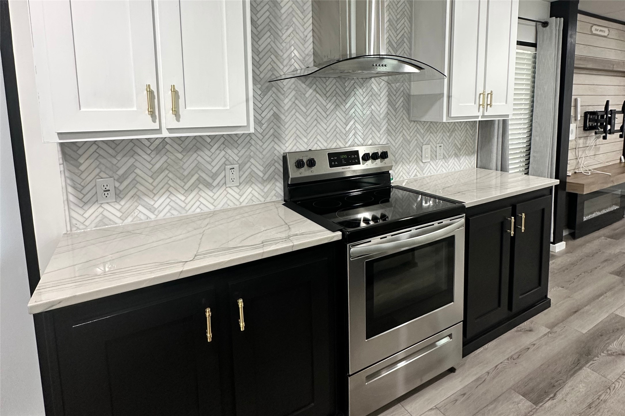 1601 East Slaughter Lane, Unit 464 Austin, TX 78747 - Photo 2 of 26 Dual tone kitchen featuring stainless steel electric range oven, light wood-type flooring, two tone cabinets, decorative backsplash, and light stone countertops