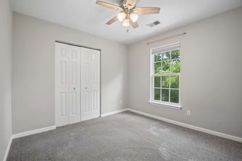 an empty room with a window and a fan