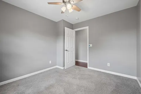 an empty room with a ceiling fan and a window