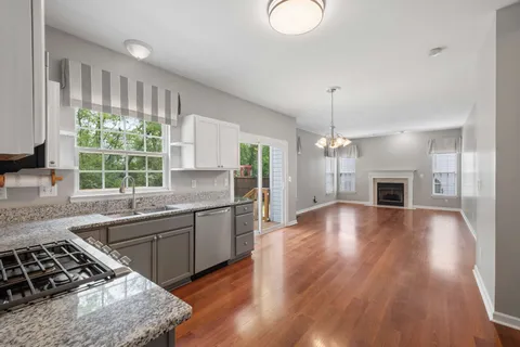 a kitchen with stainless steel appliances granite countertop a stove and a wooden floors