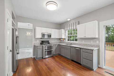 a kitchen with stainless steel appliances granite countertop a stove a sink and a refrigerator