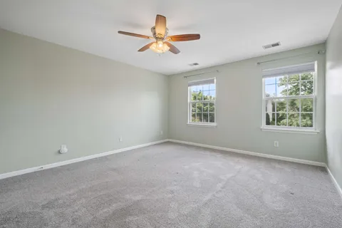 an empty room with a window and a fan