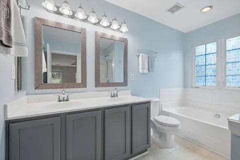 a bathroom with a sink double vanity granite and a bathtub
