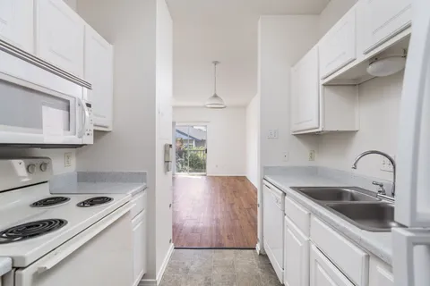 a kitchen with granite countertop a sink stove and cabinets