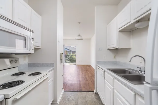 a kitchen with granite countertop a sink stove and cabinets