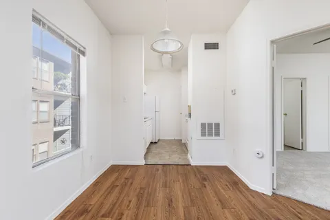 an empty room with wooden floor and windows