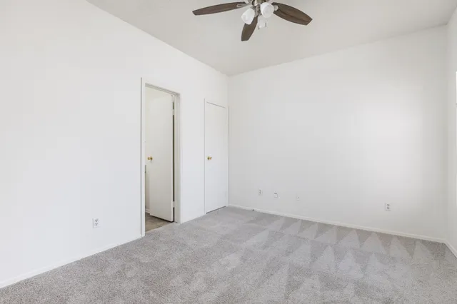 an empty room with a chandelier fan