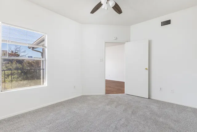 an empty room with windows and view of closet