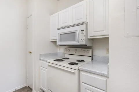 a kitchen with white cabinets and white appliances