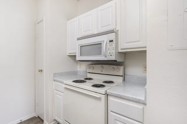 a kitchen with white cabinets and white appliances