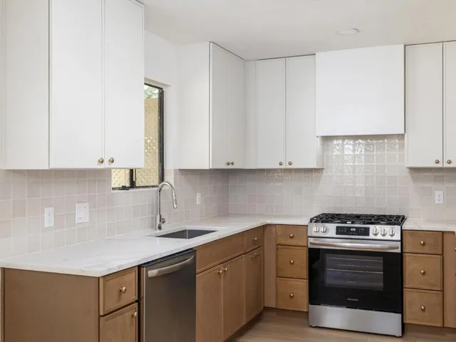 a kitchen with stainless steel appliances granite countertop a sink stove and cabinets